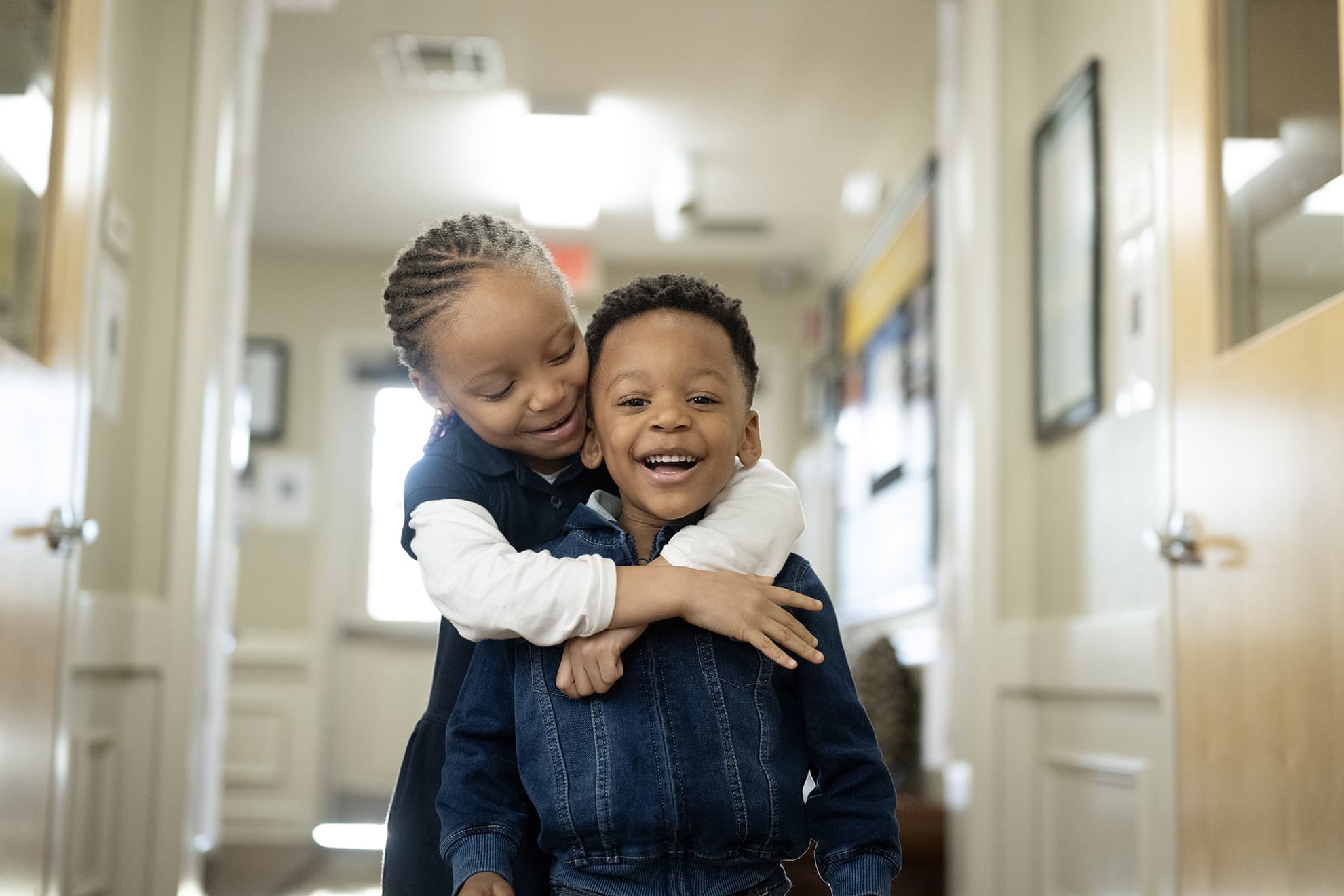 pre-k child hugging preschool child